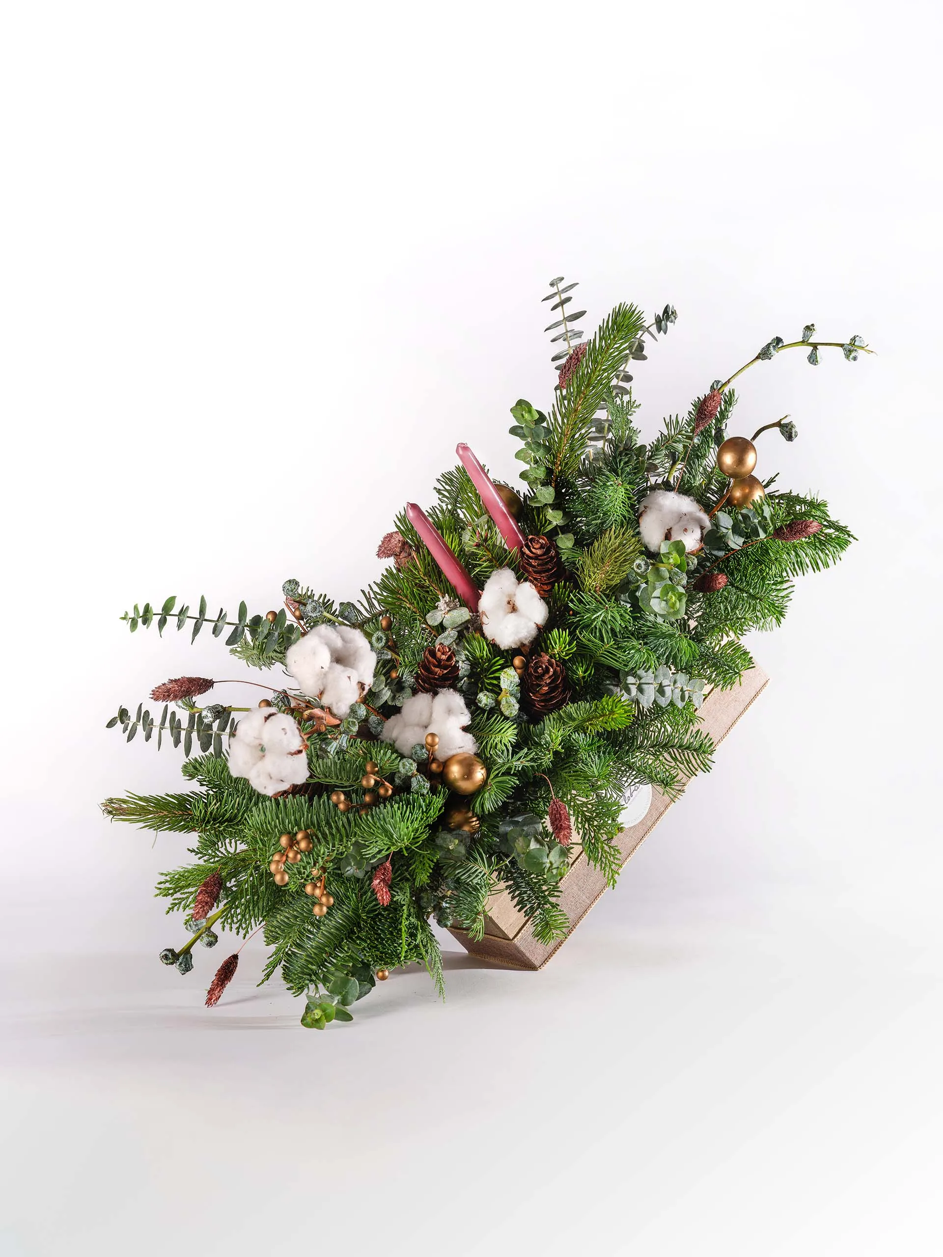 Festive Evergreen Centerpiece with greenery, cotton accents, and red candles in a wooden box