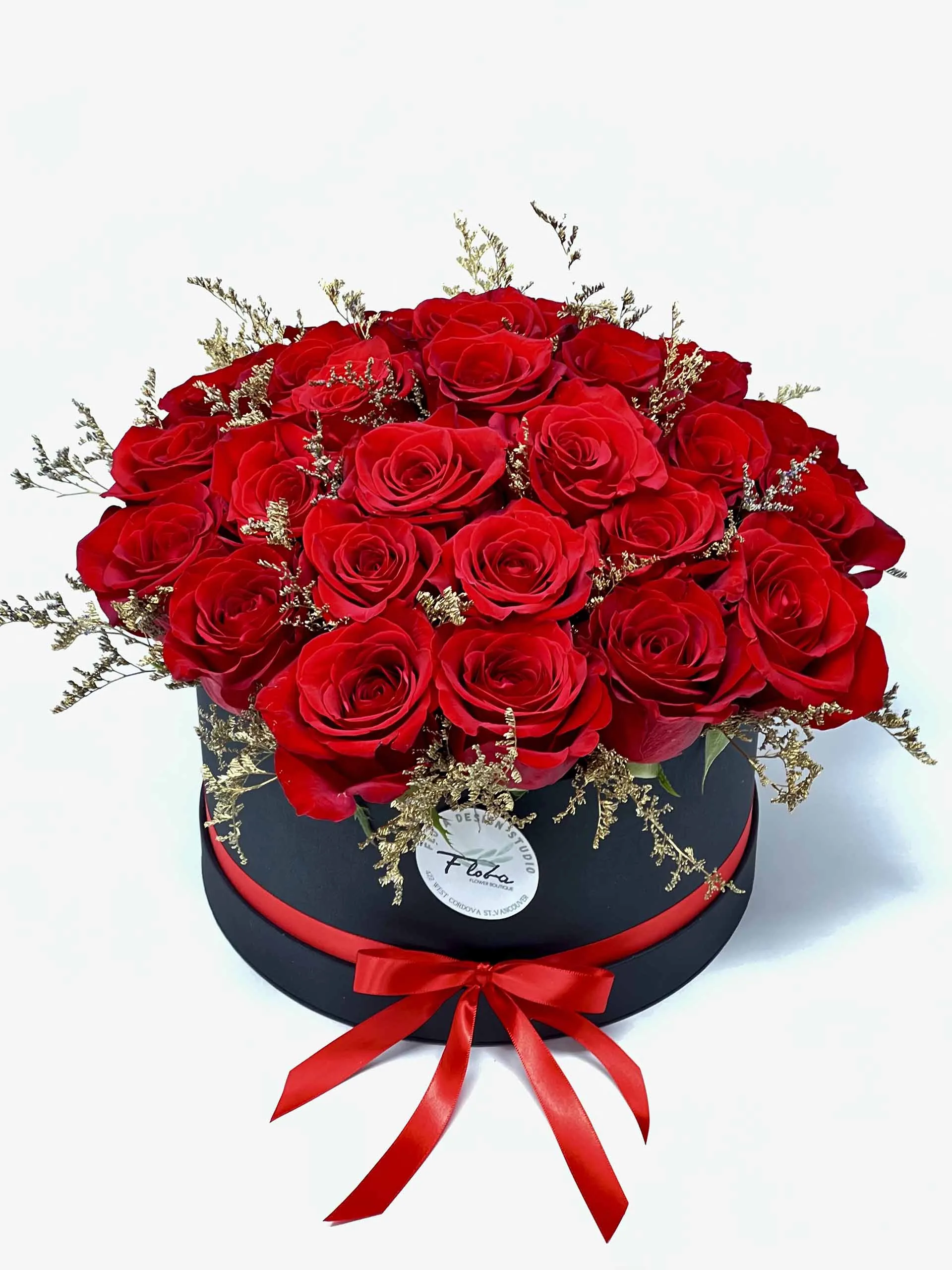 Midnight Rose Symphony featuring premium red roses with golden accents, elegantly arranged in a black box tied with a satin ribbon.
