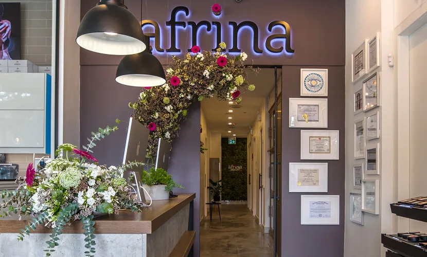 Afrina store interior with floral arrangements and certificates on display, showcasing modern elegance and professional excellence in Vancouver.