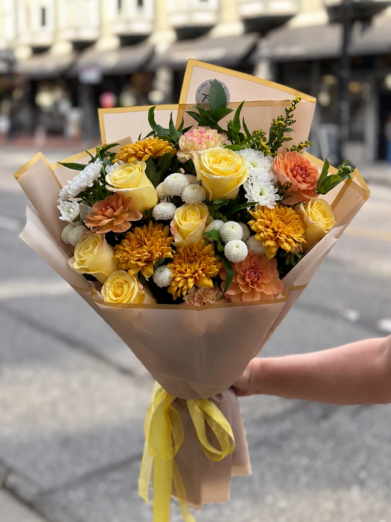 Autumn Harvest Bouquet with yellow roses, golden chrysanthemums and peach flowers in gold-edged wrapping