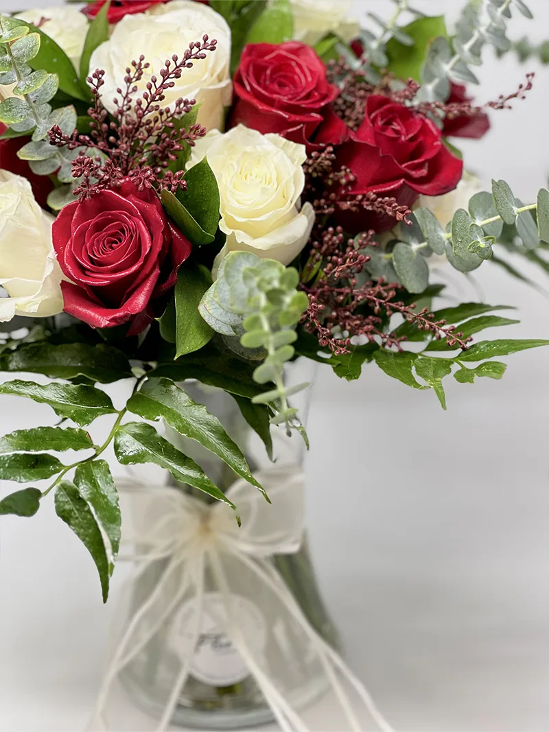 Harmony Rose Vase with a mix of red and white roses, complemented by delicate fillers and lush greenery, tied with a soft ribbon bow.