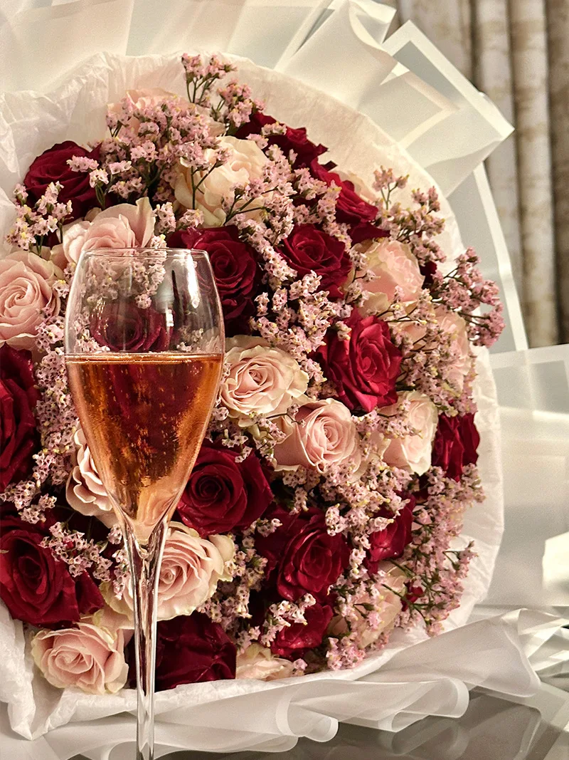 Luxurious Blush Romance Bouquet with red and pink roses, accented with delicate baby's breath, elegantly displayed for a romantic occasion.