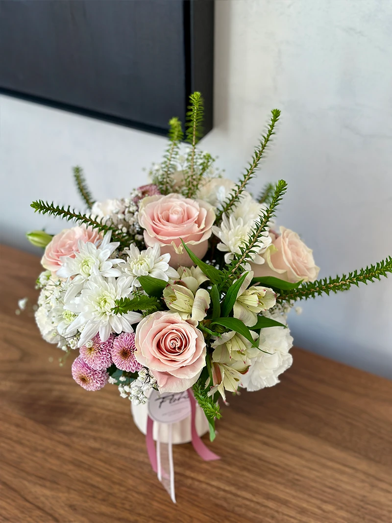 Soft pink and white flower arrangement in modern ceramic vase