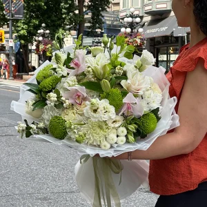 Woman holding the Pearl Garden white and green bouquet in Gastown Vancouver