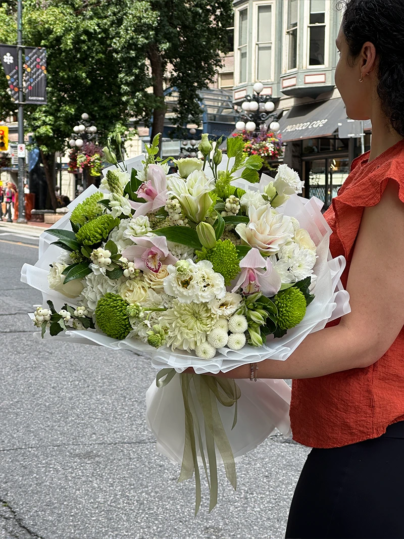 Woman holding the Pearl Garden white and green bouquet in Gastown Vancouver