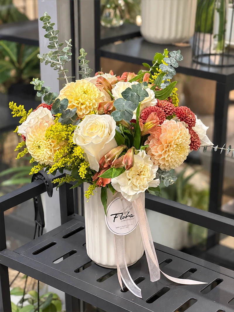 Peach Honey Flower Arrangement Angle Peach & Honey flower arrangement with peach, cream and yellow blooms in a white ribbed vase